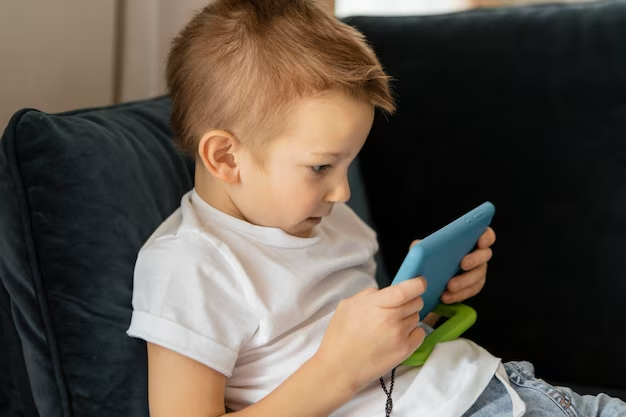 Ребенок, занятый телефоном, играет в игры и смотрит видео на экране своего мобильного устройства